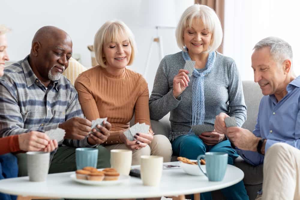assisted living vs home care: A group of multi racial seniors having fun in an assisted living facility environment
